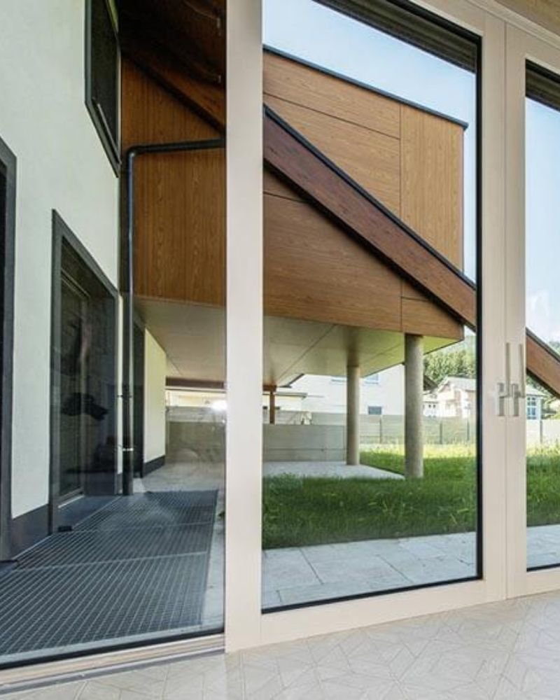 Vetrate con vista sul giardino in una casa in legno dal design contemporaneo