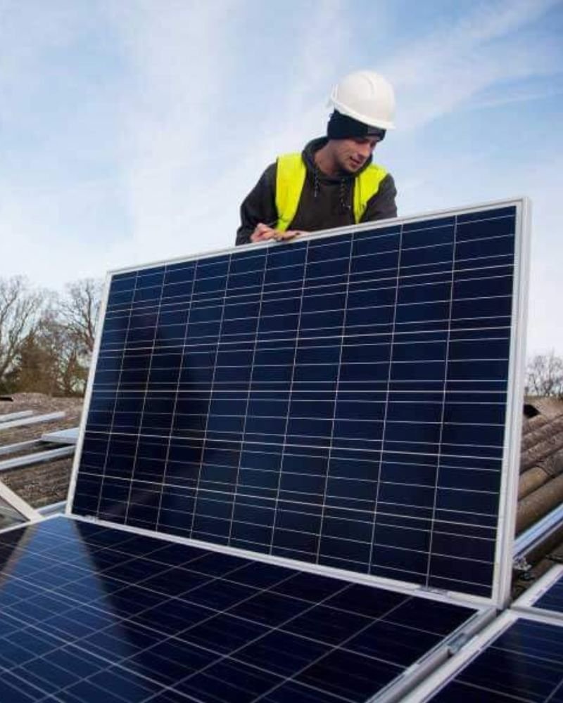 Operai installano pannelli fotovoltaici su casa a struttura lignea