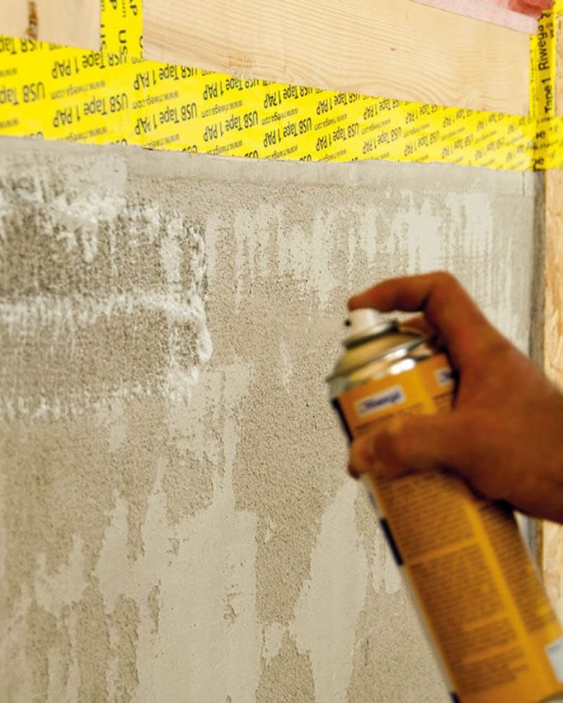 Fase di impermeabilizzazione con spray su parete in legno